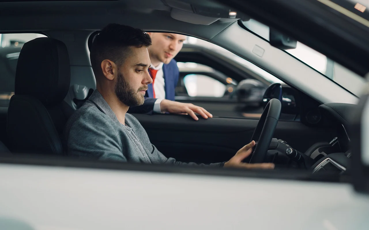 Ein Privatkunde entdeckt mit einem Berater den Innenraum eines Autos.
