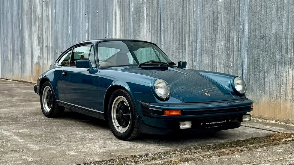 Porsche 911 SC 1982 bleu pétrole devant un hangar